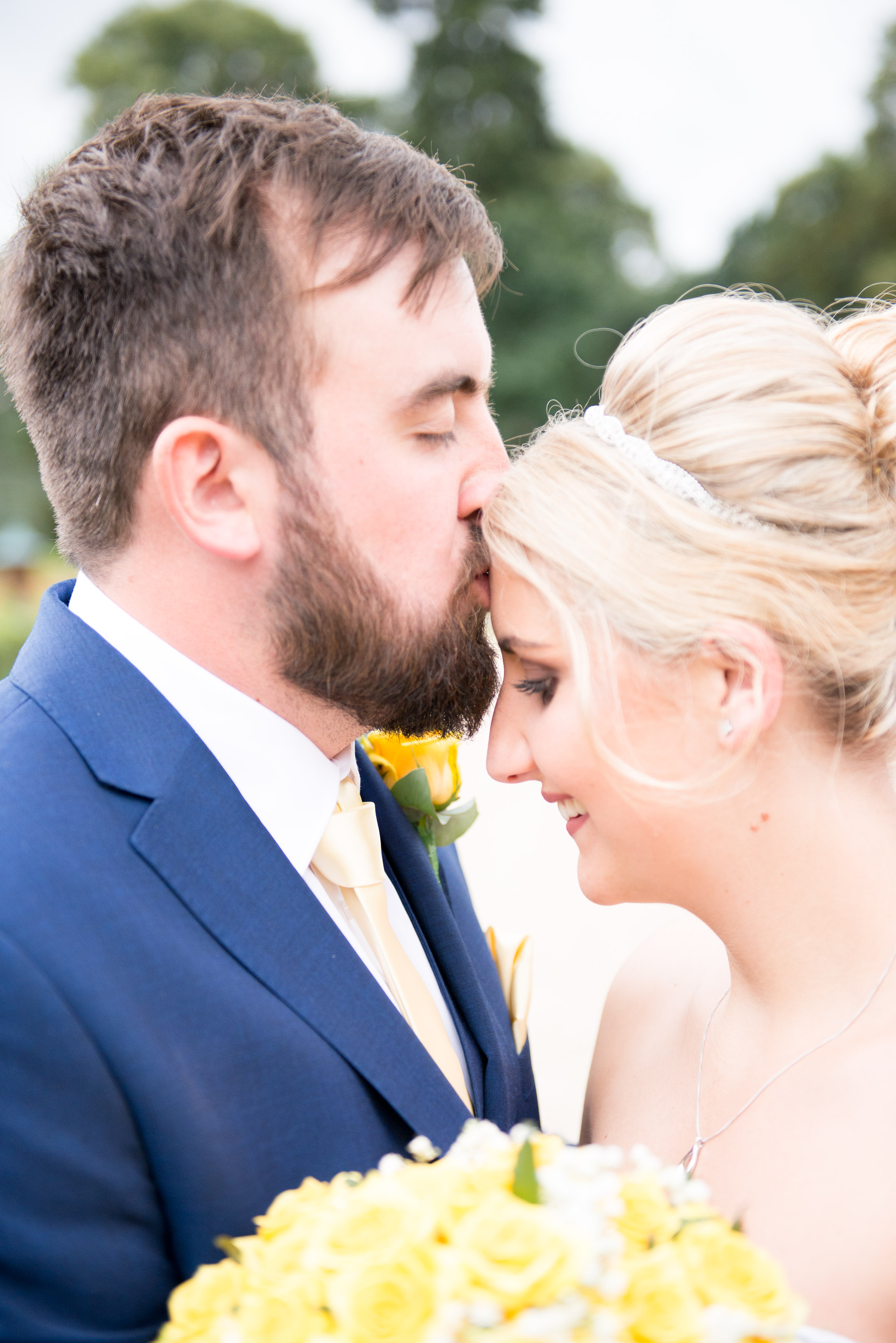 Groom kissing the brides forehead