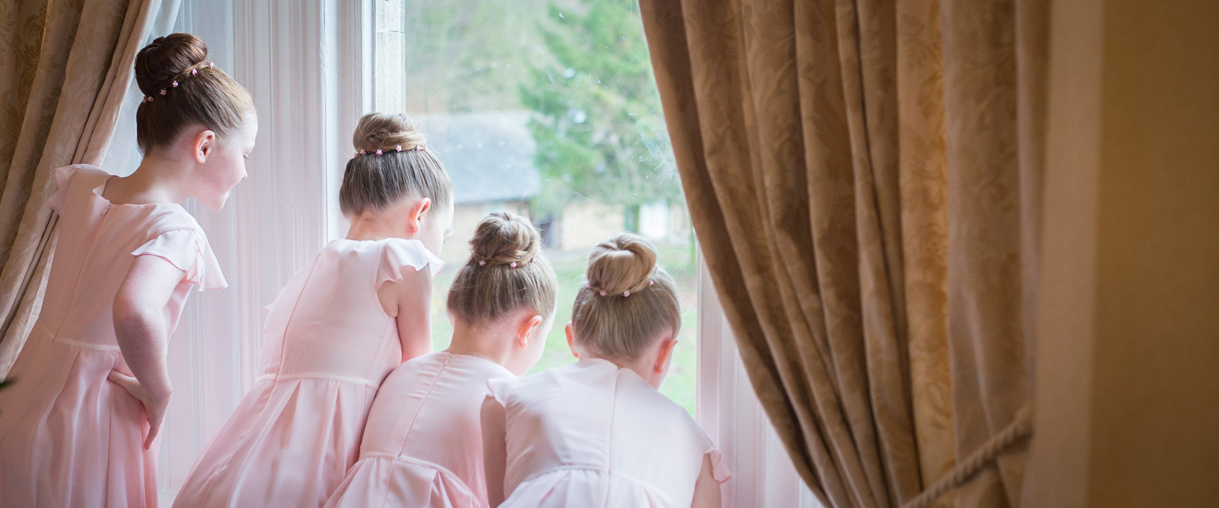 Bridesmaids looking out of the window during bridal prep. Wedding photography. www.gemmawillisphotography.co.uk