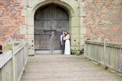 Bride and groom outside the doors across the bridge of the castle