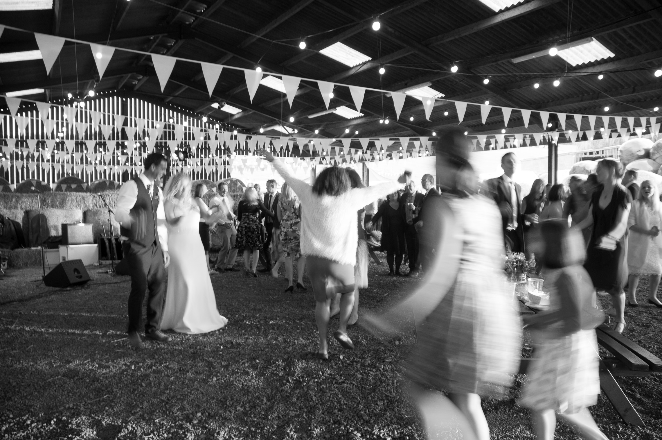 Bride and groom in the barn with guests