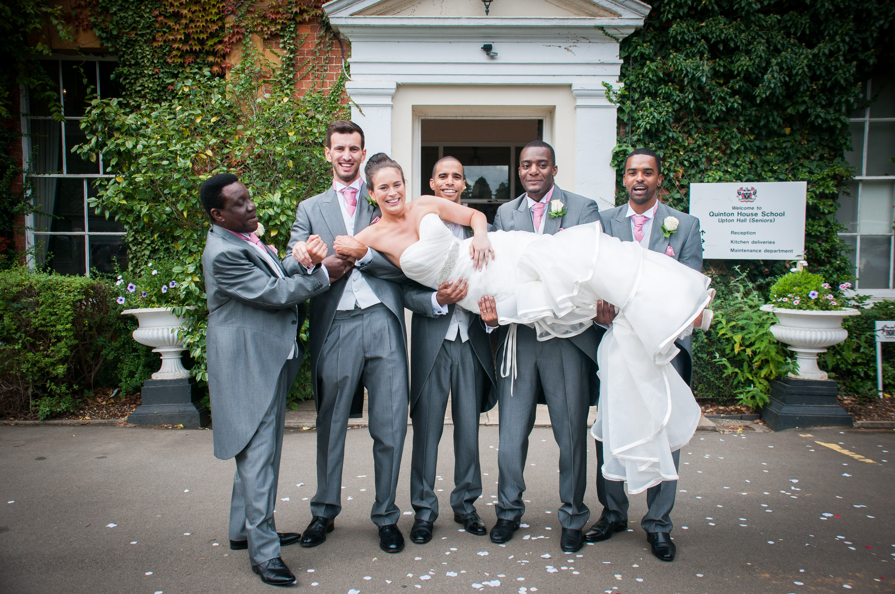 Groomsmen hold up the bride