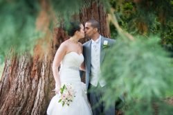 Bride and groom photographed through the trees