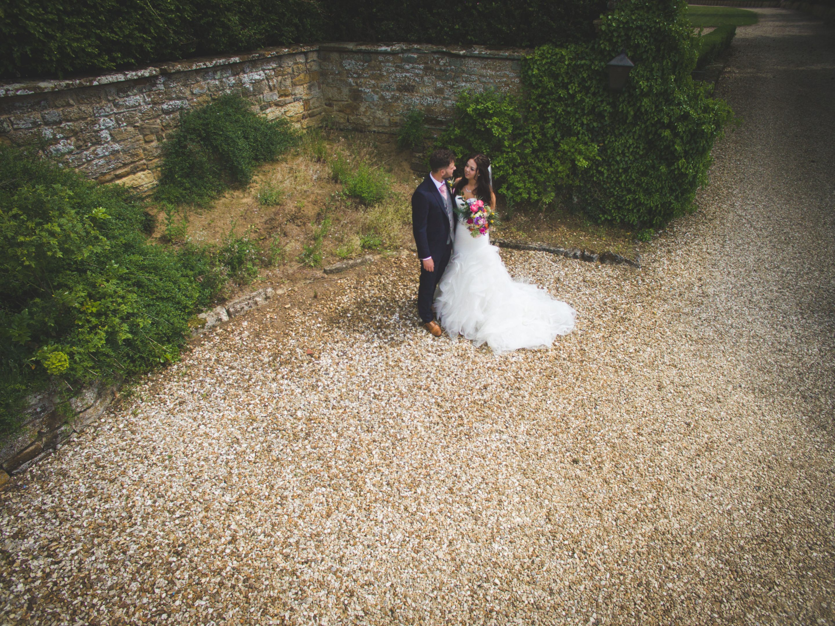 From above with the drone, the bride and groom at the side of Highgate House