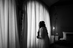 Bride looking at groom through window