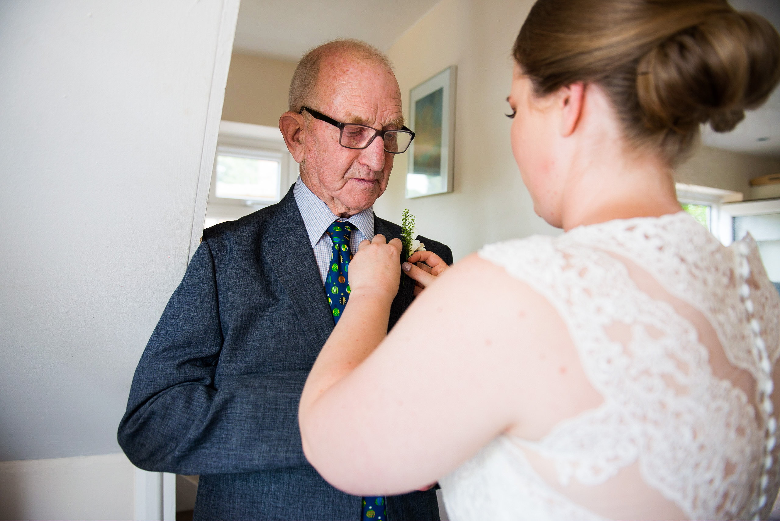 Bride putting on dads button hole